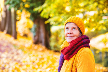 woman in her 50s walking in park in autumn