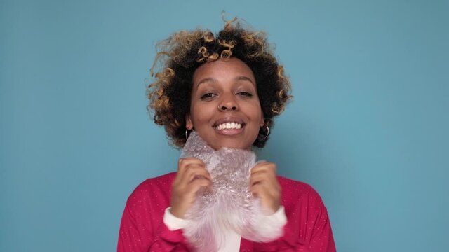 African american woman bursts bubbles on a packaging bubble wrap, trying to calm down