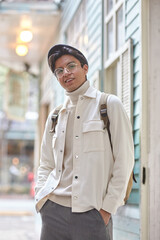 Stylish man walking down the street wearing white  sweater and jacket laughing on street