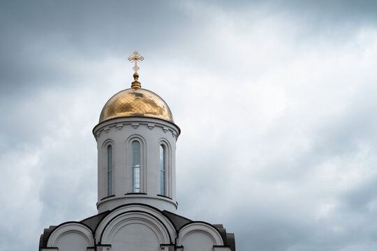 White church with golden dome and cross