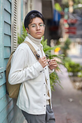 Stylish man wearing white  sweater and jacket  and standing on street