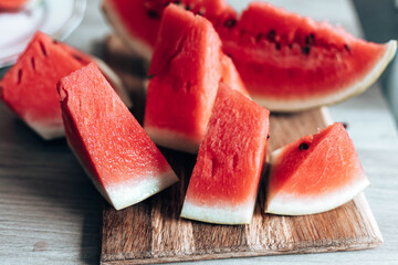 Ripe pieces of watermelon on a wooden cutting board in the kitchen. Food Backrgound.