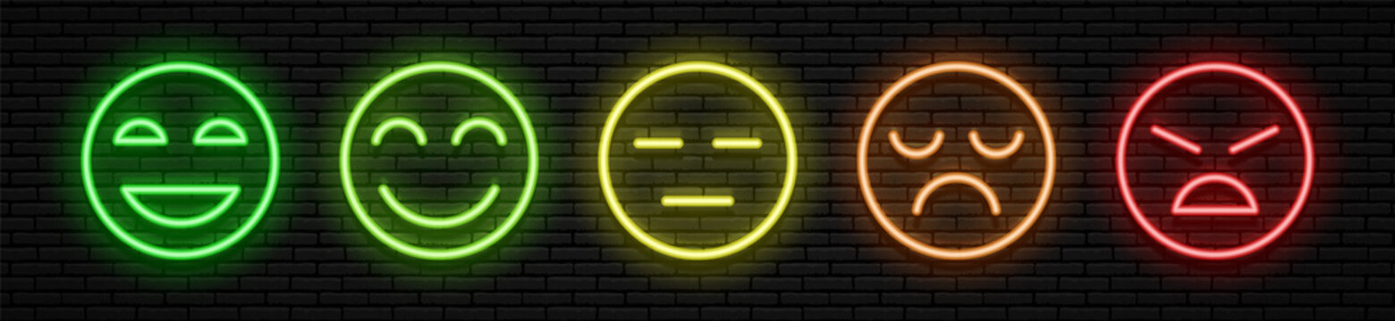 A set of five neon emoticons with different facial expressions. Joyful to angry, and in between. Green yellow orange and red colors. Against the background of a brick wall. All elements are isolated.