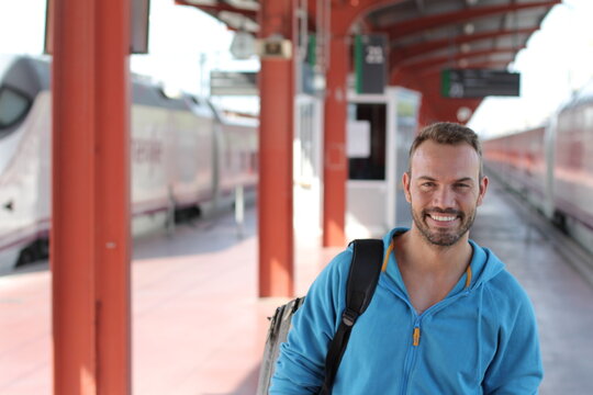 Blonde man smiling in train station