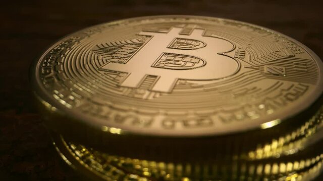 Close up slow motion detail shot of bitcoins falling and stacking on top of each other.