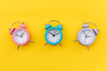Simply minimal design three ringing twin bell classic alarm clock Isolated on yellow background....