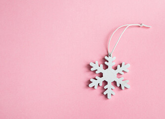 White snowflake on a pink background. Concept of Christmas, New Year, winter in minimal style, flat lay