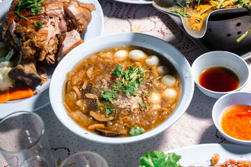 Chinese style soup; or braised fish maw in red gravy with eggs, mushroom, and bamboo shoot in white bowl. Braised Fish Maw in Red Gravy with crab in bowl.