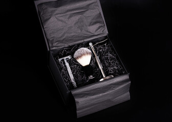 Razor,   brush and stand in a  black box on a black background.
