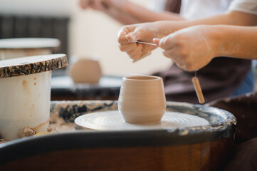 Hands of a potter, creating an earthen jar on the circle