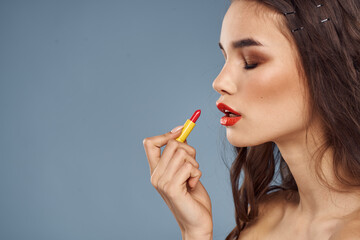 Woman with lipstick on a gray background brunette makeup with eye shadow on the eyelids