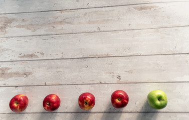 Flat lay composition of fresh green and red apples on white wooden table, space for text 