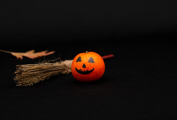orange mandarin painted like a halloween pumpkin, happy halloween citrus