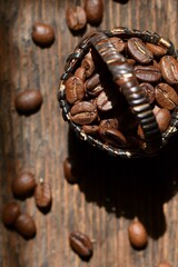 Coffee beans in a wicker basket on the background of a wooden table. Coffee composition.