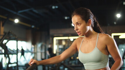 Fototapeta na wymiar Cute fitness woman training at gym. Fit girl using velosimulator in sport club