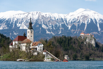 Church on lake Bled with snow-covered Alps in the background