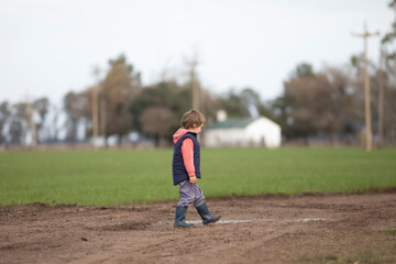 Fototapeta premium Niño jugando y corriendo por camino de tierra