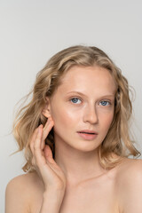 Closeup of pretty young woman face with blue eyes, curly natural blonde hair, has no makeup,...