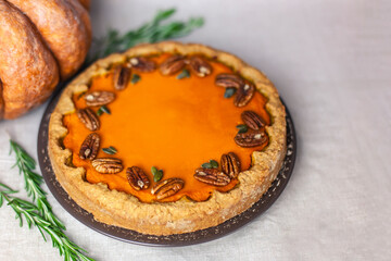 Pumpkin homemade pie on a gray linen background with top view of food ingredients for decoration