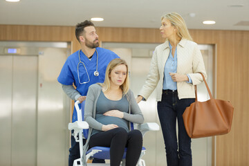 Naklejka premium pregnant woman in wheelchair by lifts in a hospital