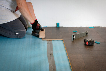 Persona que instala un suelo laminado
