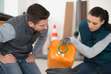 young caucasian woman fills bucket with oil