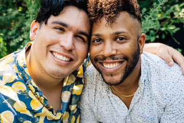 Portrait of smiling happy gay men hugging in garden