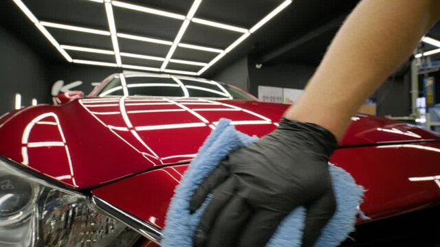Worker polish a red car. Car detailing - Men are using machinery car polishers maintenance to remove marks repair according to the surface of the car's paint before contin
