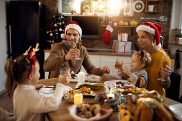 Joyful family toasting during Christmas lunch in dining room