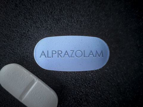 Alprazolam sedative medication pill on black