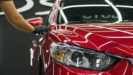 Car service worker applying nano coating on a car detail. - Powered by Adobe