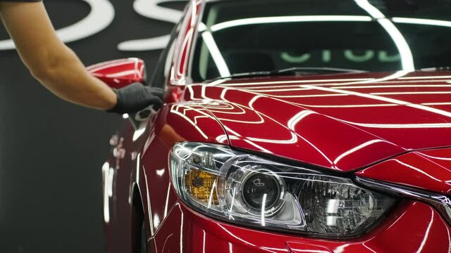 Car service worker applying nano coating on a car detail.