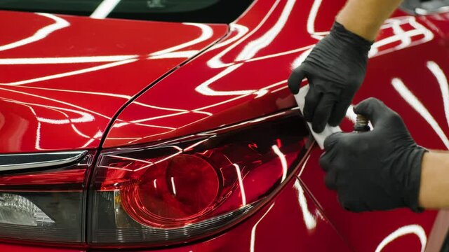 Car service worker applying nano coating on a car detail.