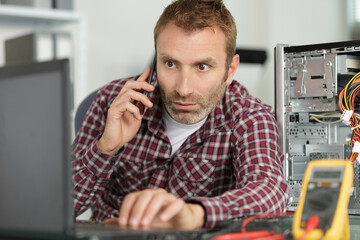 technician repairing a computer and phone to the customer
