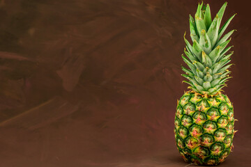 Ripe pineapple on brown background
