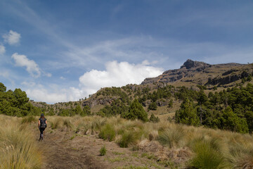 Stunning landscape view of a forested area with volcan iztaccihuatl on the horizon top in clouds