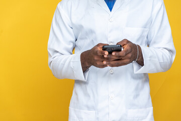 a young black man in a lab coat using his phone