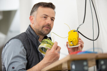electrician checking socket voltage using multimeter