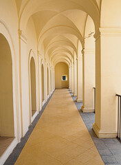Pasillo de arcos amarillos y techo abovedado en el castillo de la ciudad de Spoleto, Italia, verano...