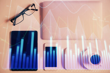 Multi exposure of financial chart hologram over desktop with phone. Top view. Mobile trade platform concept.