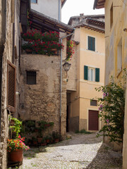 Fototapeta na wymiar Rincones de paisaje urbano de la ciudad de Spoleto, con fachadas y flores, en Italia, verano de 2019.