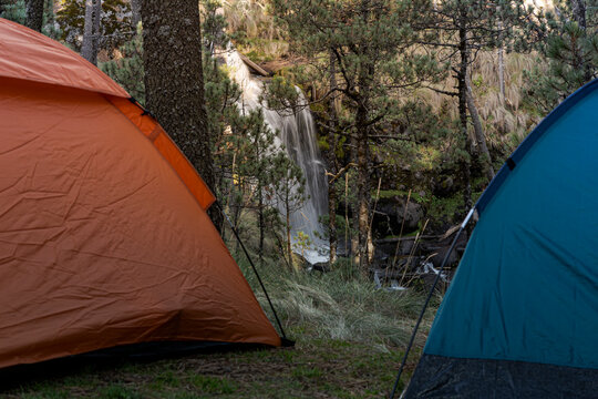 A Tent Stands Camps At A Shore Of A Waterfall For A Wild Camping, Away From Everything