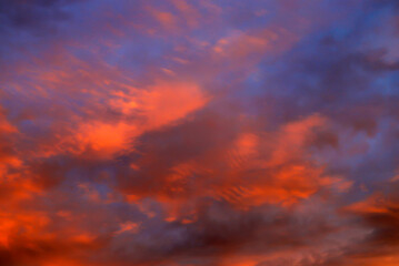Fototapeta na wymiar Beautiful red, orange cumulus clouds against a dark sky at sunset in the evening, climate change, global warming. Scenic landscape background, fantasy clouds.