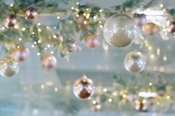 Fototapeta na wymiar Ceiling christmas decorations in modern mall, shopping center or exhibition place on blurred bokeh background. Baubles hanging on trees branch