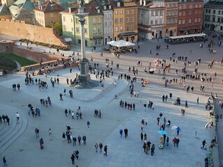 Top view of the sunlit city square with people walking along it © Olena Netkach