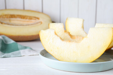 Slices of delicious ripe melon on white wooden table, closeup