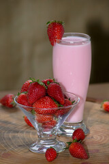 ripe strawberries in a glass bowl with condensed milk with a glass of milkshake on the side. on rustic wooden table. vibrant colors
chocolate donut