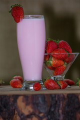 ripe strawberries in a glass bowl with condensed milk with a glass of milkshake on the side. on rustic wooden table. vibrant colors
chocolate donut