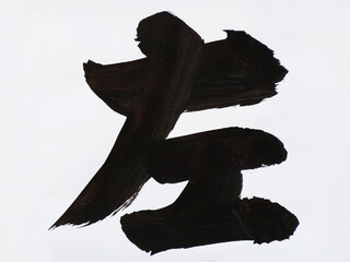 毛筆で紙に書いた左の漢字