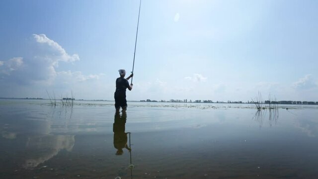Woman fishing on the river. Amateur angler woman casting the lure from the land